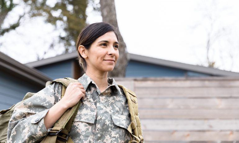 Soldier outside her home