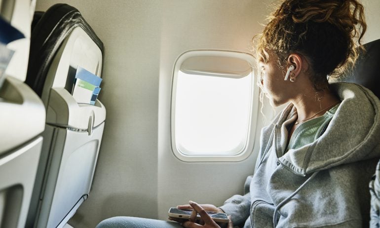 girl looking out window with american airlines basic economy ticket