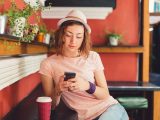 Young woman using cell phone in coffee shop