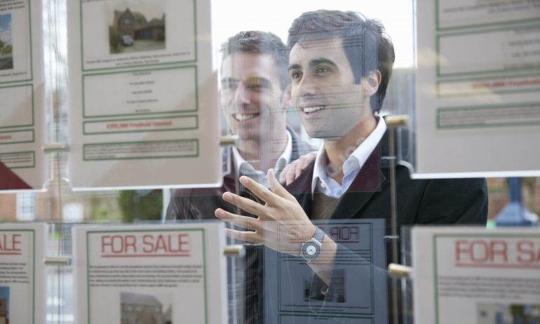 Couple looking into estate agents window