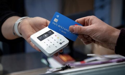 A customer holds a credit card up to the SumUp Plus reader