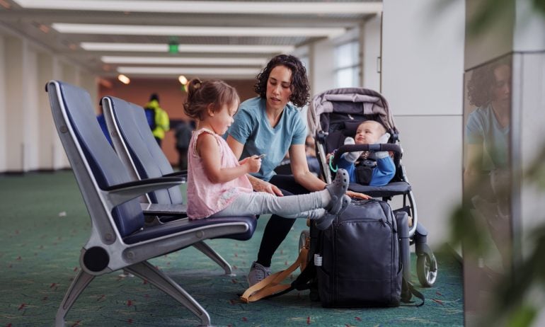 Mother and two children wait patiently in an airport terminal