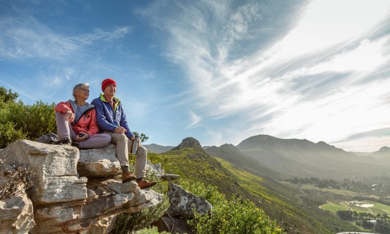 Senior couple resting on a mountain hike