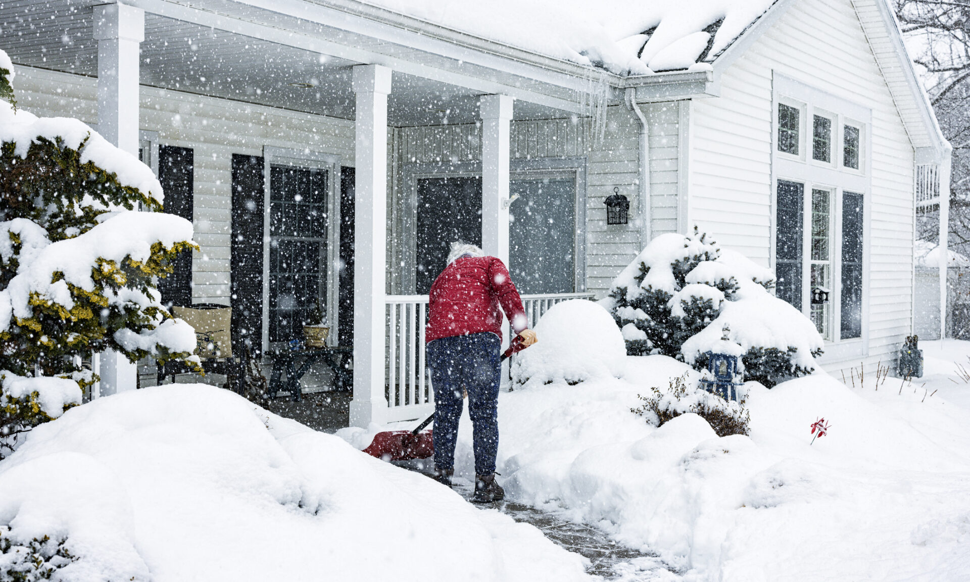 person shoveling snow outside their house