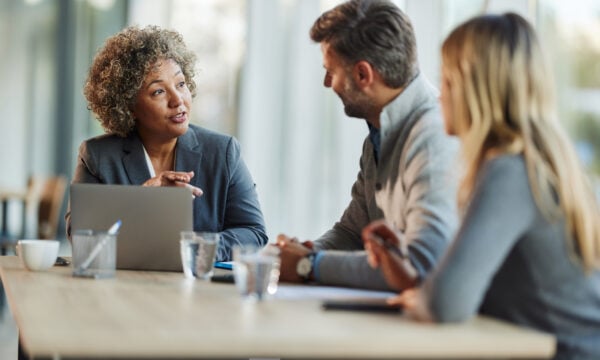 Three people talking at desk