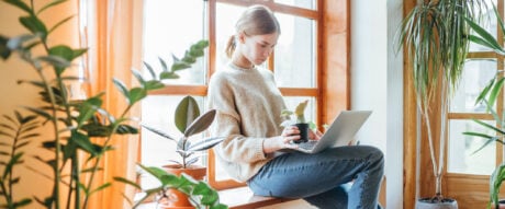 Young woman using laptop to search for information about how mortgages work in Canada.