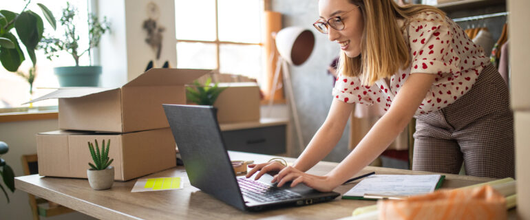 Young female entrepreneur receiving new orders in her e-commerce clothing shop