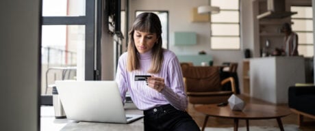 Young woman doing online shopping using credit card at home.