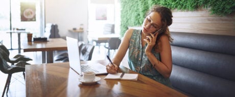 Shot of a young woman using a laptop and smartphone while making online purchases with one of her many credit cards to maximize points.