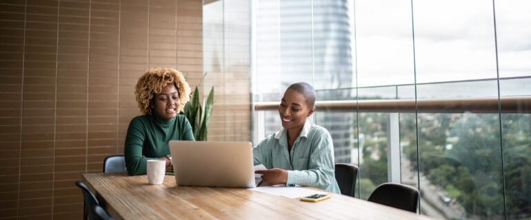 Mortgage lender and a client talking together in front of a laptop.