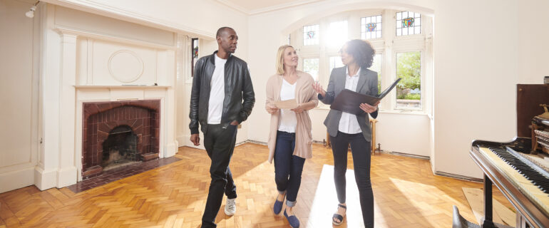 an estate agent shows a couple around a refurbished period home