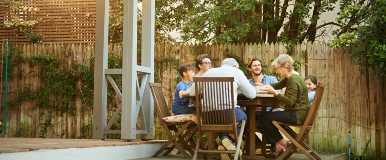 Three generations at a dinner table discussing where a high ratio mortgage is worth it.