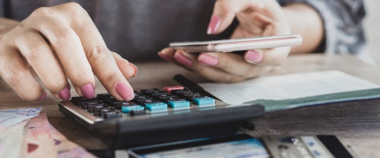 Woman calculating what she owes to a debt collector.