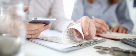 Two people at a table calculating their debt-to-income ratio.