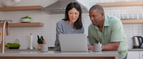 Husband and wife calculate their mortgage LTV on a laptop.