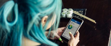 Woman checks on her bank fees and charges using a mobile phone.