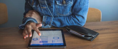 Black person browsing types of bank accounts on a tablet.