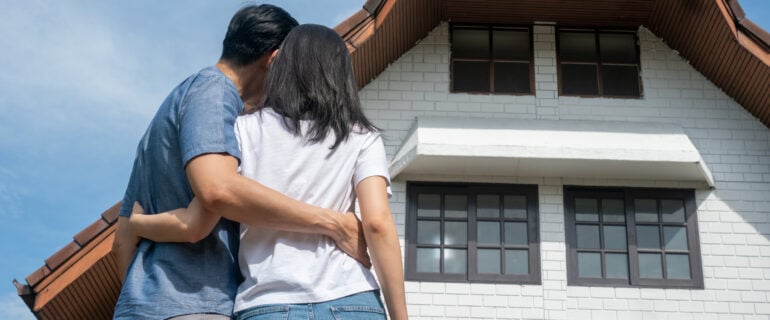 Couple standing in front of a rent-to-own home.