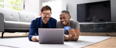 Two men use buy now pay later while shopping on their laptop.