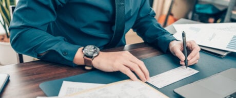 Man looking at cheque for bank account and routing numbers.