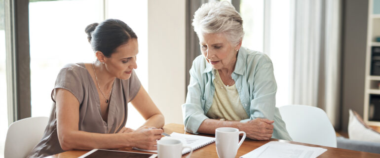 Mother and daughter at a table discussing estate planning.