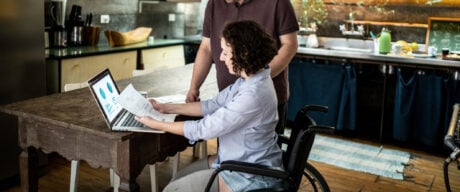 Women researches disability tax credit at her kitchen table.