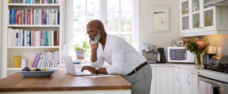 Shot of a mature man using a laptop and reviewing his Notice of Assessment, which acts as a kind of receipt to show that your tax return has been received and reviewed.