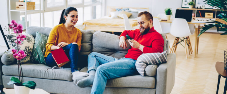 A man and a woman on a couch enjoying conversation.