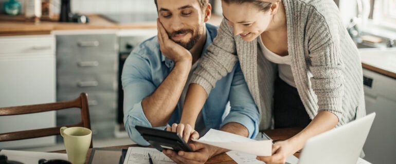 Photo of a young couple using a shared chequing account to manage home finances.