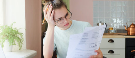 Caucasian woman looking at overpaid credit card bill.