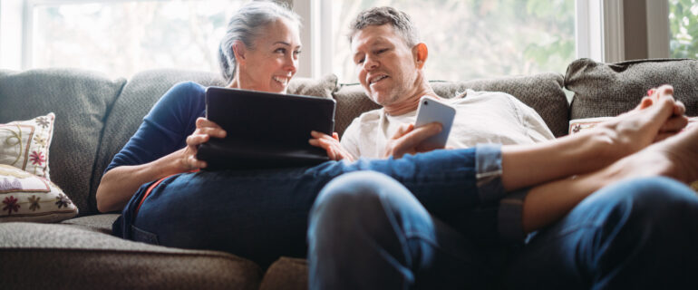 Couple sits on their couch thinking about what to look for when buying a house.