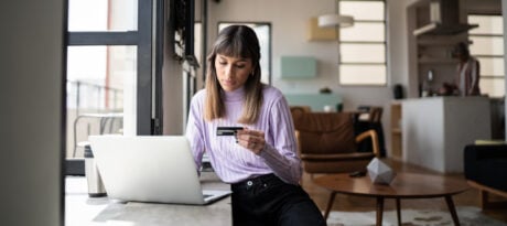 Young woman online shopping using credit card at home