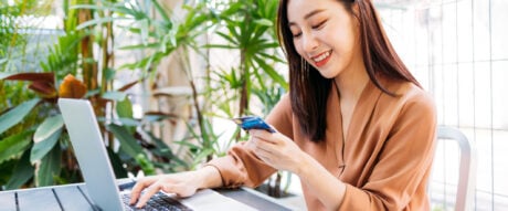 Woman making payment on laptop with card