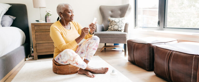 Senior woman using her phone to check her net worth.