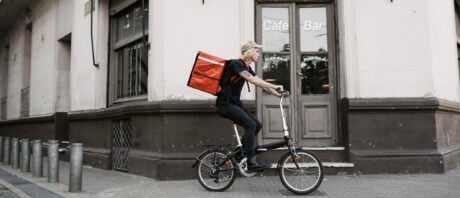 Man on bicycle makes delivery for his side hustle.