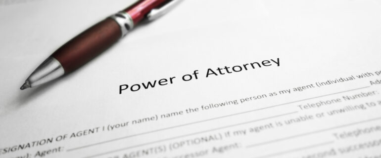 Power of attorney documents are pictured on a desk with a pen.