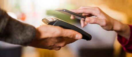 Person makes a mobile payment using a smart phone.