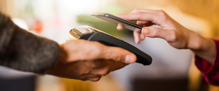 Person makes a mobile payment using a smart phone.