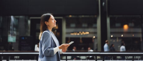 Asian business woman thinks about open banking while walking down the street.