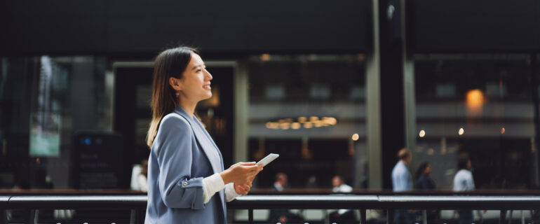 Asian business woman thinks about open banking while walking down the street.