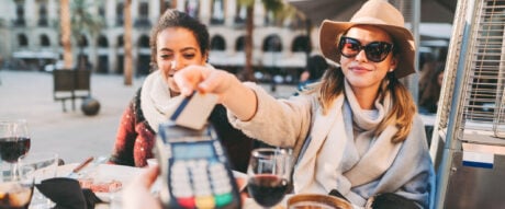 Woman using a prepaid card to pay for a meal in a restaurant.