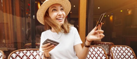 Woman in a hat pays for her cafe meal with a metal credit card.