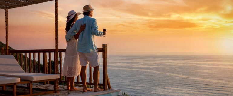Couple enjoys a stunning sunset on a vacation booked through their black credit card.