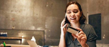 Young woman activates her new American Express CA card over the phone.