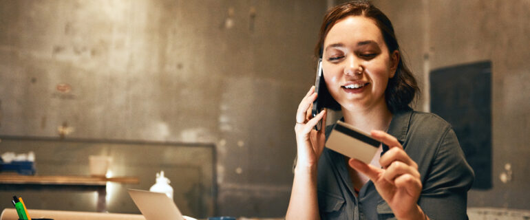 Young woman activates her new American Express CA card over the phone.