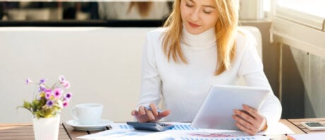 Young woman calculating capital gains tax after the sale of an investment.