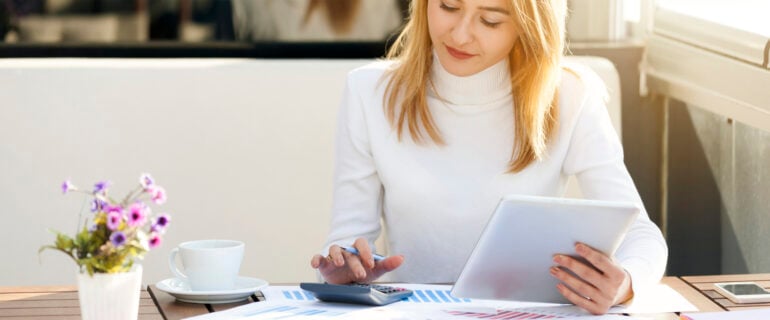 Young woman calculating capital gains tax after the sale of an investment.