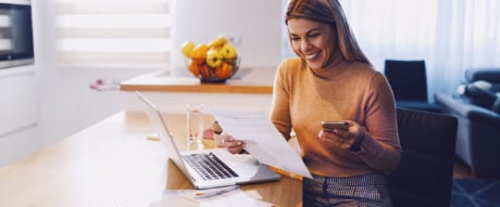 Woman checking her computer to see the interest earned on an investment.