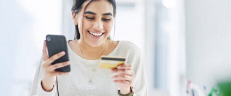 Young woman uses her bank card to access her no-fee chequing account.