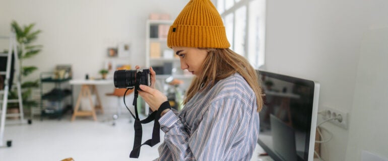 A young female freelance photographer tests her new camera.